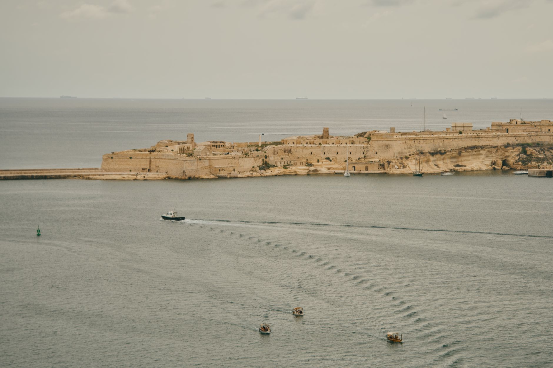 A scenic view of the historic Fort St. Elmo with boats in the Mediterranean Sea, Valletta, Malta.