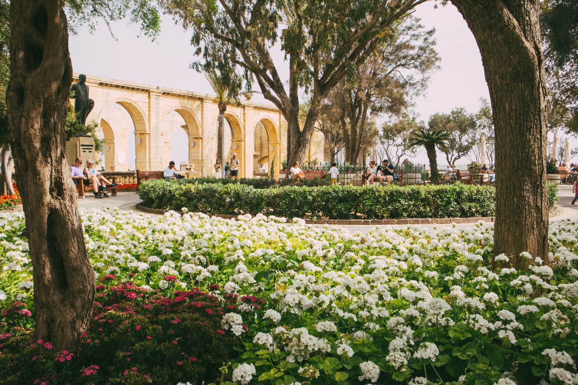 Lush garden with flowers and people enjoying Upper Barrakka Gardens' scenic view, perfect for travel inspirati